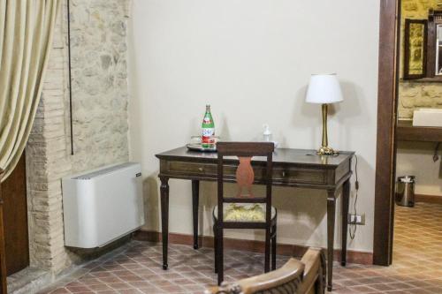 a desk with a bottle of soda and a chair in a room at Castel di Pietra in Pietra Montecorvino