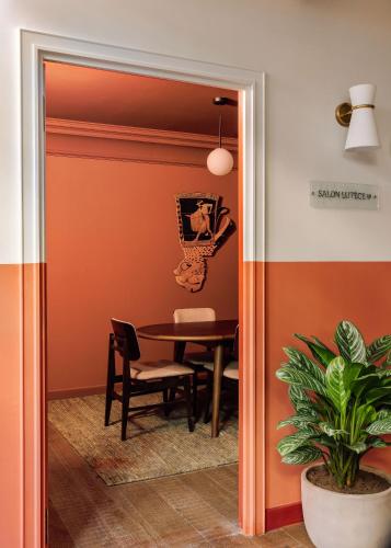 a dining room with orange walls and a table at Le Jardin de Verre by Locke in Paris