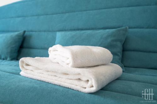 une pile de serviettes blanches posées sur un lit dans l'établissement Uranus - Proche A10 - 2V - Parking, à Saint-Pierre-des-Corps