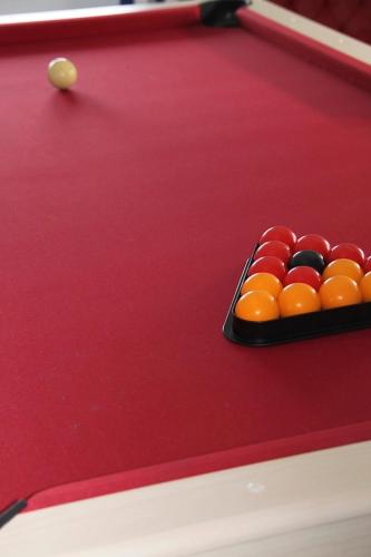 a red felt pool table with a cue ball at Face aux Flots in La Cotinière