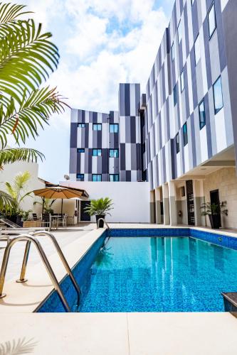 a swimming pool in front of a building at Zind Naaba Hotel in Lomé