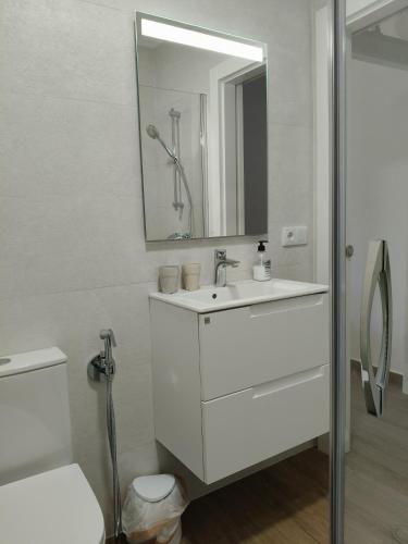 a white bathroom with a sink and a mirror at La Aldea 3 , CENTRO de Comillas, Parking Público y vistas Universidad Pontificia in Comillas