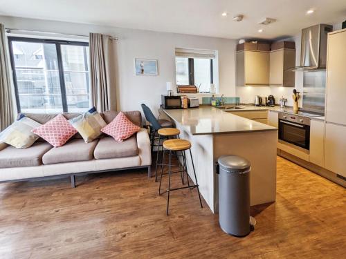 a living room with a couch and a kitchen at Folly View in Newport