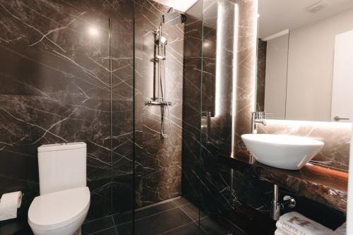 a bathroom with a white toilet and a sink at Apartamento Porta14 1 in Chaves