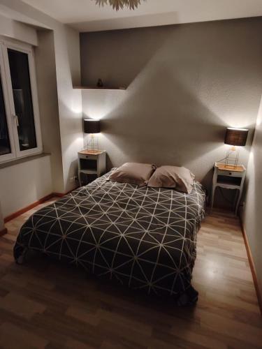 une chambre avec un lit avec deux lampes sur deux tables dans l'établissement Centre ville jardin privatif, à Morteau