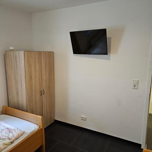 a bedroom with a bed and a tv on the wall at HafenApartement in Bremerhaven