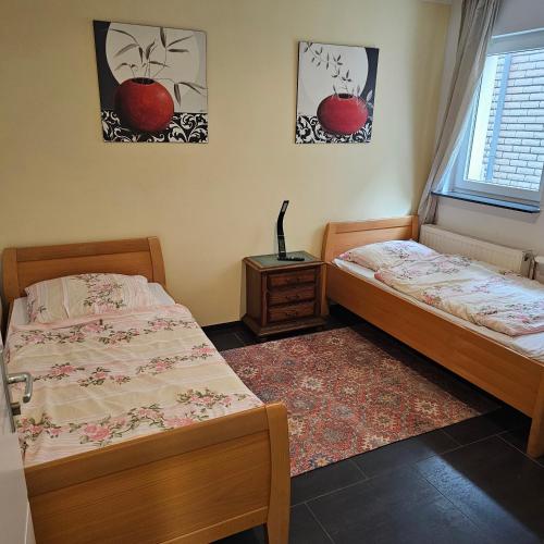 two beds in a bedroom with two posters of apples on the wall at HafenApartement in Bremerhaven