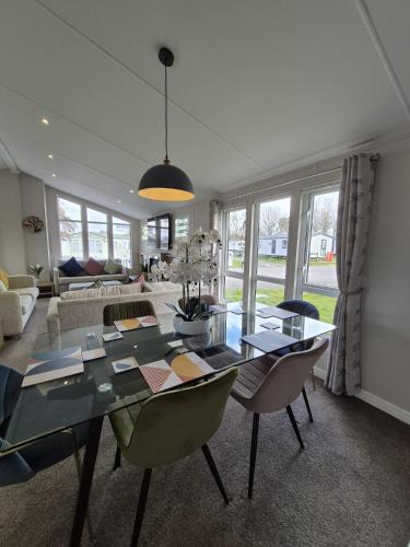a dining room with a glass table and chairs at The Retreat 2 bedroom lodge with sauna! in Walton-on-the-Naze