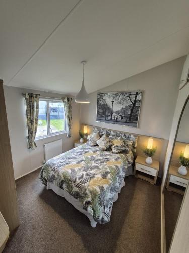 a bedroom with a large bed and two windows at The Retreat 2 bedroom lodge with sauna! in Walton-on-the-Naze