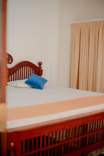 a bed with a blue pillow on top of it at Dreams City Hotel and Apartment in Aluthgama