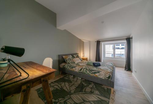 a bedroom with a bed and a desk and a window at L'Evasion Urbaine #Hypercentre#Confort in Clermont-Ferrand