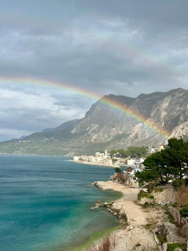 a rainbow over a beach with a town and the ocean at ADRIA MIRIS apartments in Drasnice