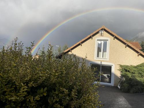 a rainbow over a house with at Gîtes Belle Vue in Saint-Léger-les-Mélèzes