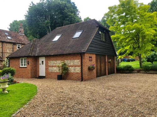 a small brick house with windows on a gravel driveway at The Mouse House in Harpsden