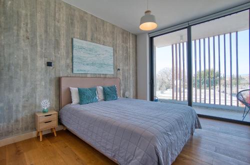 a bedroom with a bed and a large window at Avenue 202 1 BED in Paphos