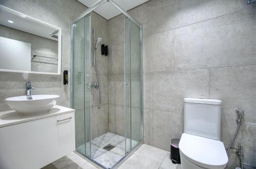 a bathroom with a shower and a toilet and a sink at Avenue 202 1 BED in Paphos
