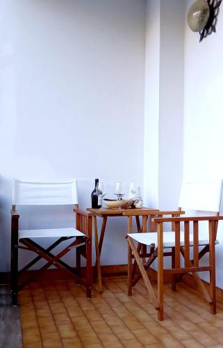 a table with two chairs and a table with wine glasses at Appartamento Cuore delle Dolomiti in Cencenighe