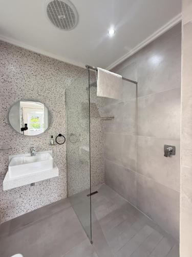 a bathroom with a glass shower and a sink at 26 Montego Bay at Caribbean Estates in Port Edward