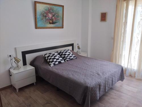 a bedroom with a bed with two pillows on it at Boutique Algarrobo in Denia