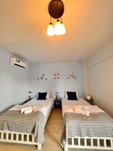 a bedroom with two beds and a ceiling at Triple J hotel Trang in Trang