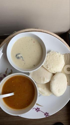 a plate with a bowl of soup and some chips at Nagashree stay inn in Chikmagalūr