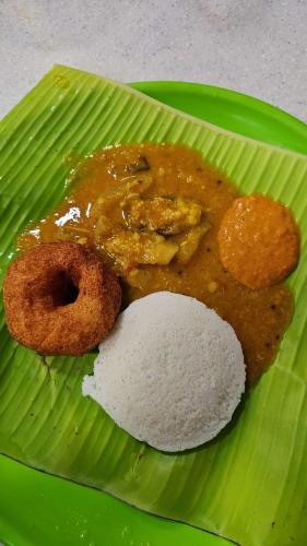 a green plate with some food on a banana leaf at Nagashree stay inn in Chikmagalūr