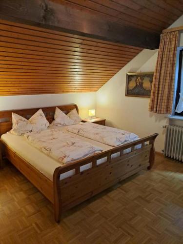 a bedroom with a large wooden bed in a room at Pension Schlossbergblick in Simonswald