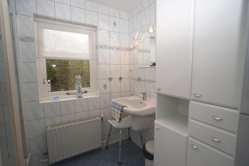 アウウドルプにあるHaringvliet 135 - Noordzeepark Ouddorp NOT INTENDED FOR COMPANY OR WORK-RELATED STAYSの洗面台と窓のある白いバスルーム