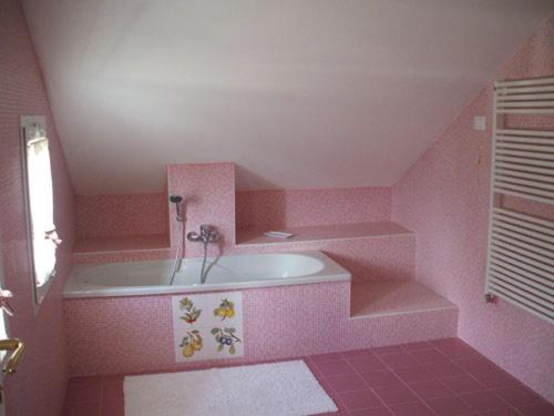 uma casa de banho cor-de-rosa com uma banheira e um lavatório. em Agriturismo Palmero em Alassio