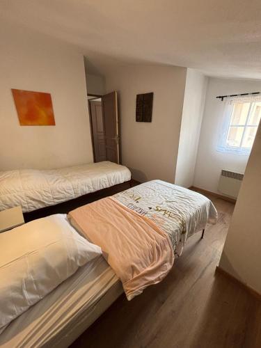 une chambre avec deux lits et une fenêtre dans l'établissement Maison de vacances, à Gallargues-le-Montueux