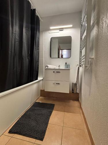 une salle de bain avec un lavabo et un miroir dans l'établissement Maison de vacances, à Gallargues-le-Montueux