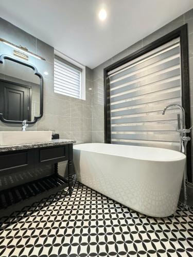 a bathroom with a tub and a sink and a mirror at Kana Boutique Hotel Ninh Bình in Ða Gia