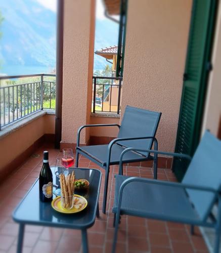 a table with a plate of food and a bottle of wine at La casa al lago BMOR love&lake in Mezzegra