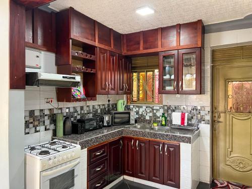a kitchen with wooden cabinets and a white stove top oven at Benja holiday home in Katale