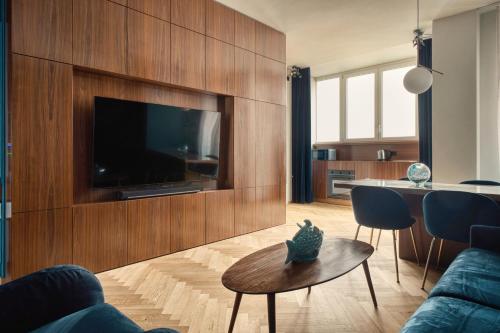 a living room with a flat screen tv on a wooden wall at JOIVY Elegant apartment Zaffiro near Porta Venezia in Milan