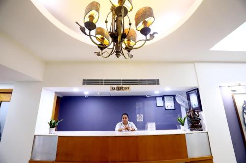 a man standing at the counter of a dental office at The Corus Hotel in New Delhi