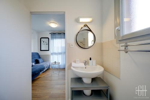 une salle de bain avec un lavabo et un miroir dans l'établissement Neptune - Proche A10 - 2V - Parking, à Saint-Pierre-des-Corps