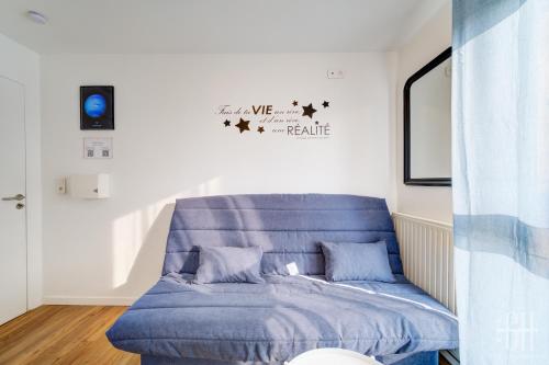 - un lit dans une chambre avec un canapé bleu dans l'établissement Neptune - Proche A10 - 2V - Parking, à Saint-Pierre-des-Corps