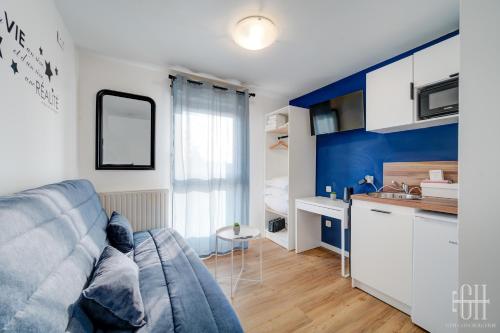 un salon avec un canapé et une cuisine dans l'établissement Neptune - Proche A10 - 2V - Parking, à Saint-Pierre-des-Corps