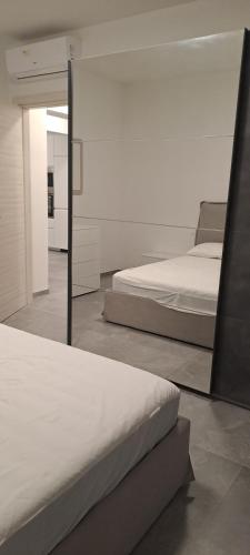 a bedroom with two beds and a mirror at 2 Appartamento Cervia Viale Diana 3 Piano Secondo in Cervia