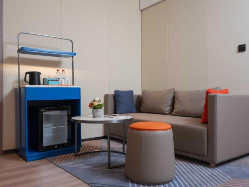 a living room with a couch and a table at Holiday Inn Express Turpan, an IHG Hotel in Turfan