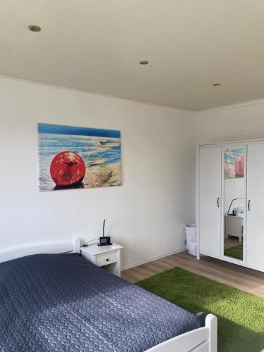 a bedroom with a bed and a painting on the wall at Hütti's Hütte in Oldendorf