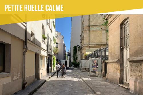 un groupe de personnes marchant dans une rue dans l'établissement Perfect apartment - Marais II, à Paris