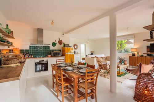 une cuisine et une salle à manger avec une table et des chaises dans l'établissement Amaya - A 10min de la Plage, à Anglet