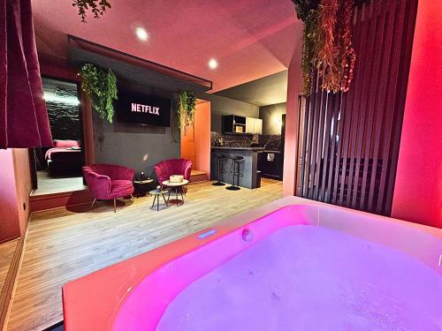 - une baignoire rose dans une chambre avec cuisine dans l'établissement Suite Obsidian - Love Room au coeur d'Orange, à Orange