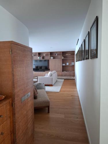 a living room with a white couch and wooden floors at Porto Sunset flat in Vila Nova de Gaia