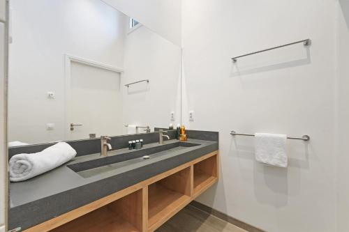 a bathroom with a sink and a mirror at Villa Super VIP | 4 pers. (Villa 68) in Ouddorp