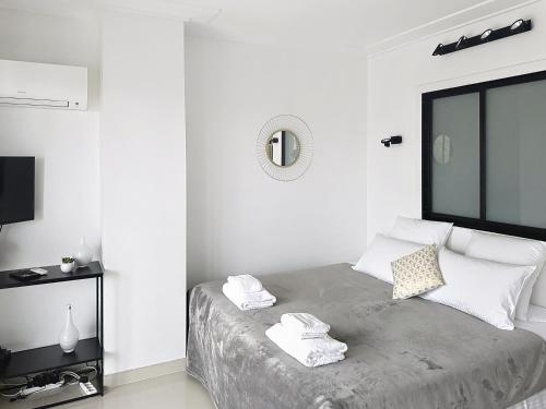une chambre blanche avec un lit avec des serviettes dessus dans l'établissement Studio apartment on La Croisette with terrace, à Cannes