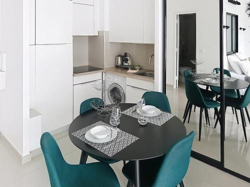 une cuisine et une salle à manger avec une table et des chaises noires dans l'établissement Studio apartment on La Croisette with terrace, à Cannes