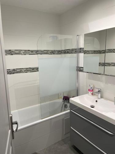 une salle de bain avec une baignoire, un lavabo et une douche dans l'établissement Résidence verdoyante et calme, à Chambly